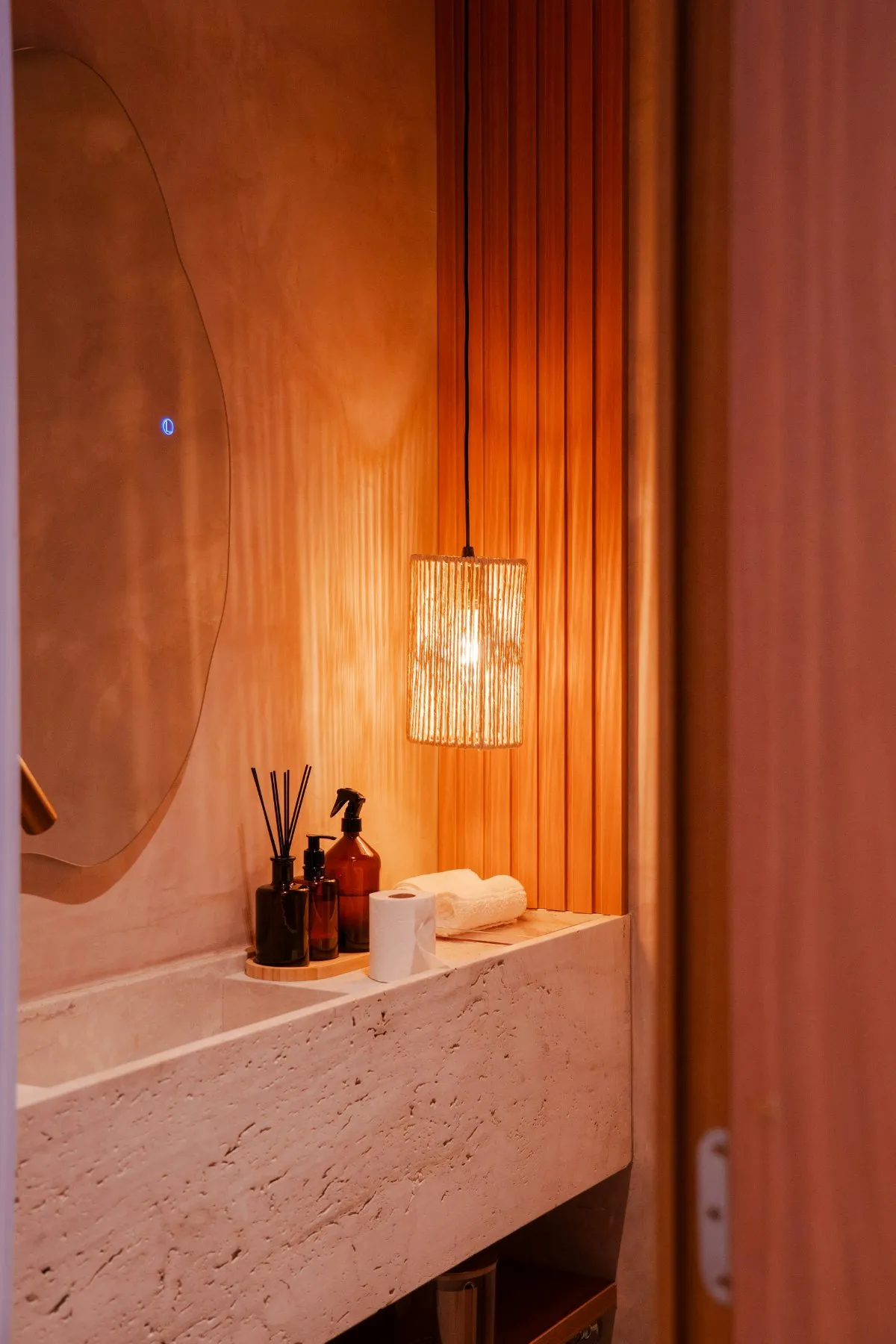 Badkamer met hanglamp en natuurstenen wastafel